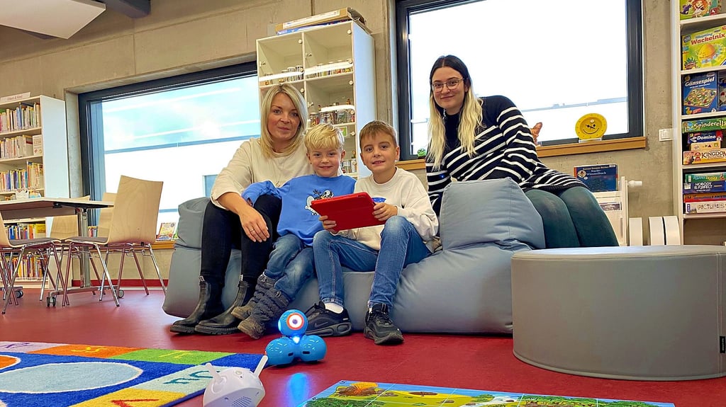 Erkunden die Welt der Roboter: Christiane Jacobi (35), ihre Söhne Carl (4) und Fritz (8) – und Alin Rossi (31), Mitarbeiterin der Stadt- und Regionalbibliothek.