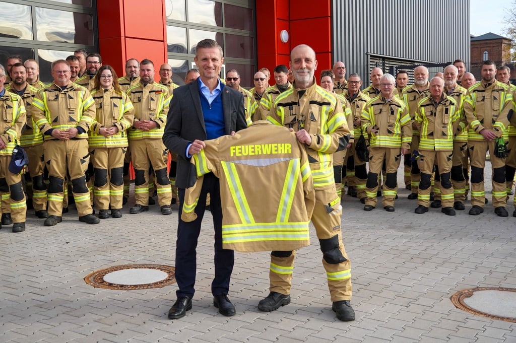 Oscherslebens Bürgermeister Benjamin Kanngießer (l.) übergibt die neue Einsatzbekleidung an Stadtwehrleiter Carsten Loof.