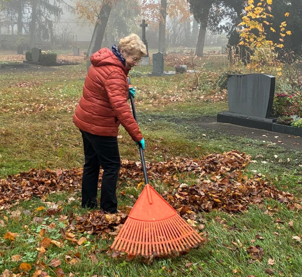 Laubaktion im Nebel: Auch Brigitte Püls vom Kirchenvorstand unterstützt die jährliche Pflege des Friedhofs.