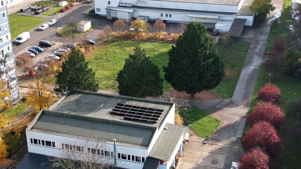 Im Vordergrund das alte IKC-Gebäude, in der Mitte die Freifläche vor dem Supermarkt, auf der der Neubau entstehen soll.