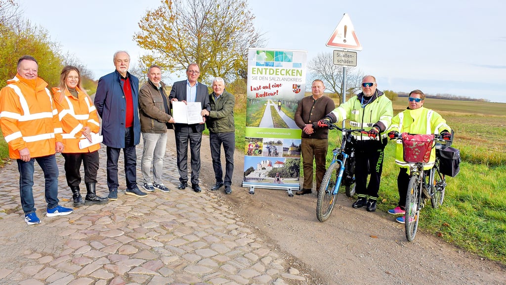 Der Fachdienstleiter des Salzlandkreises, Tilo Wechselberger, seine Mitarbeiterin Jana Elbe, der Planer  Lutz Koslowski, Verbandsgemeinde-Bürgermeister Michael Stöhr, Landrat Markus Bauer, Egelns Bürgermeister Reinhard Luckner sowie  der  stellvertretende Bürgermeister der Gemeinde Börde-Hakel, Dirk Bartsch (von links),  gaben im Beisein von  zwei Radfahrern den Startschuss für die Planungen zum Umbau der  Kreisstraße von Hakeborn nach Egeln zur Fahrradstraße. 