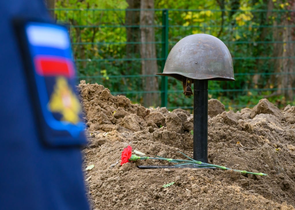 Ein Stahlhelm eines im Zweiten Weltkrieg gefallenen sowjetischen Soldaten schmückt ein Grab.