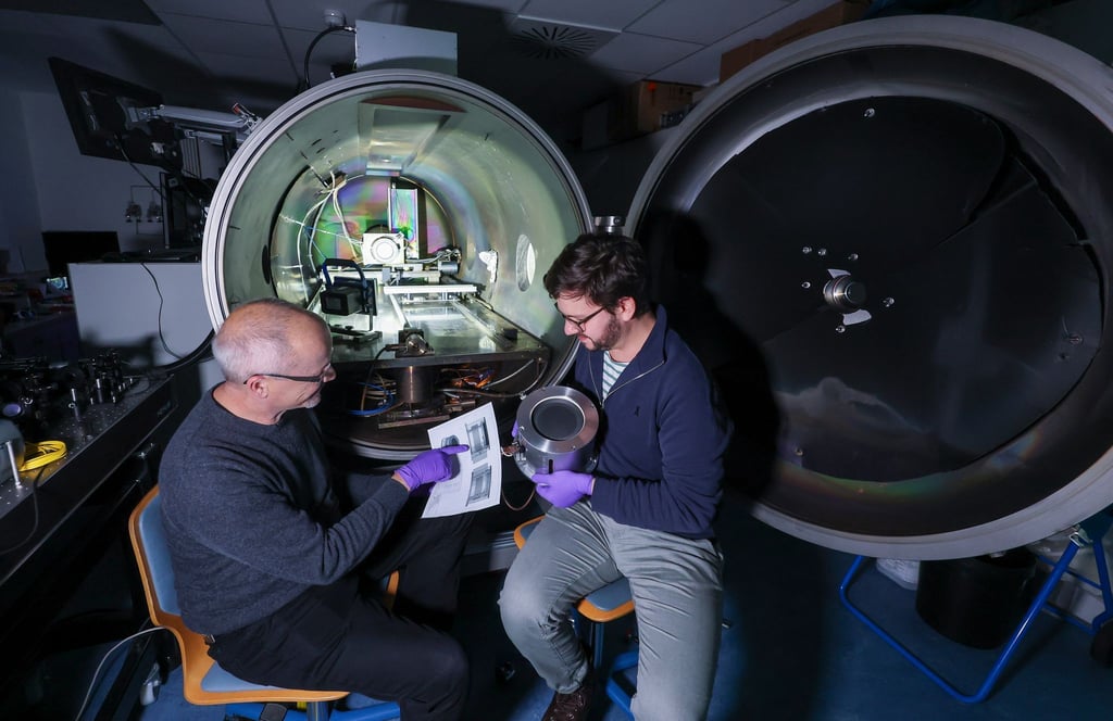 Daniel Spemann (links) und Lukas Pietzonka vom Leibniz-Institut für Oberflächenmodifizierung (IOM) bereiten einen Laborversuch mit einem Ionentriebwerk vor.