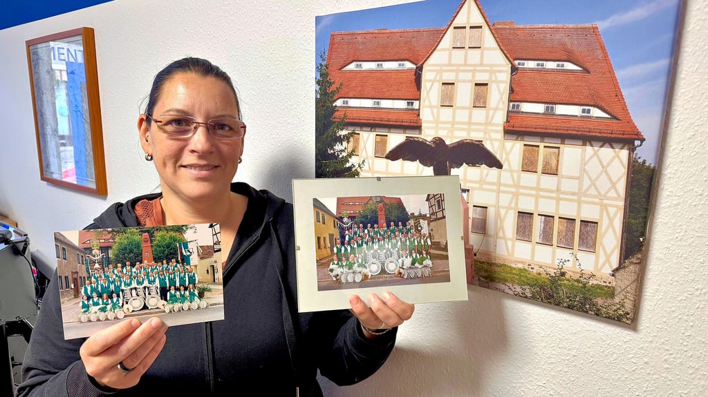 Trainerin Mandy Thieme zeigt zwei Fotos aus der Vergangenheit von Spielmannszug und Cheerleader.