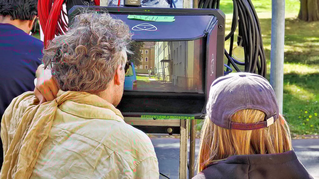 Regisseur Julian Radlmair überwacht im August 2024 die Dreharbeiten in Sangerhausen auf einem Monitor.