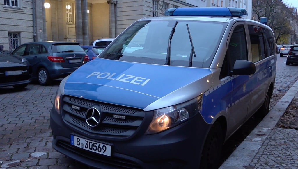 Ein Polizeiauto steht nach vermeintlichen Anschlagsandrohungen vor einer Berliner Schule.