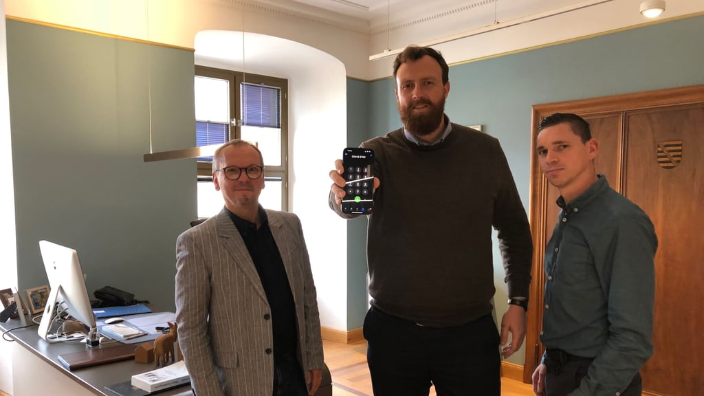 Der Weißenfelser Oberbürgermeister Martin Papke präsentiert mit Sven Hantschel (l.) und Michael Kraft im Rathaus, wie KI-Assistent Charly künftig Fragen von Bürgern am Telefon bearbeitet.
