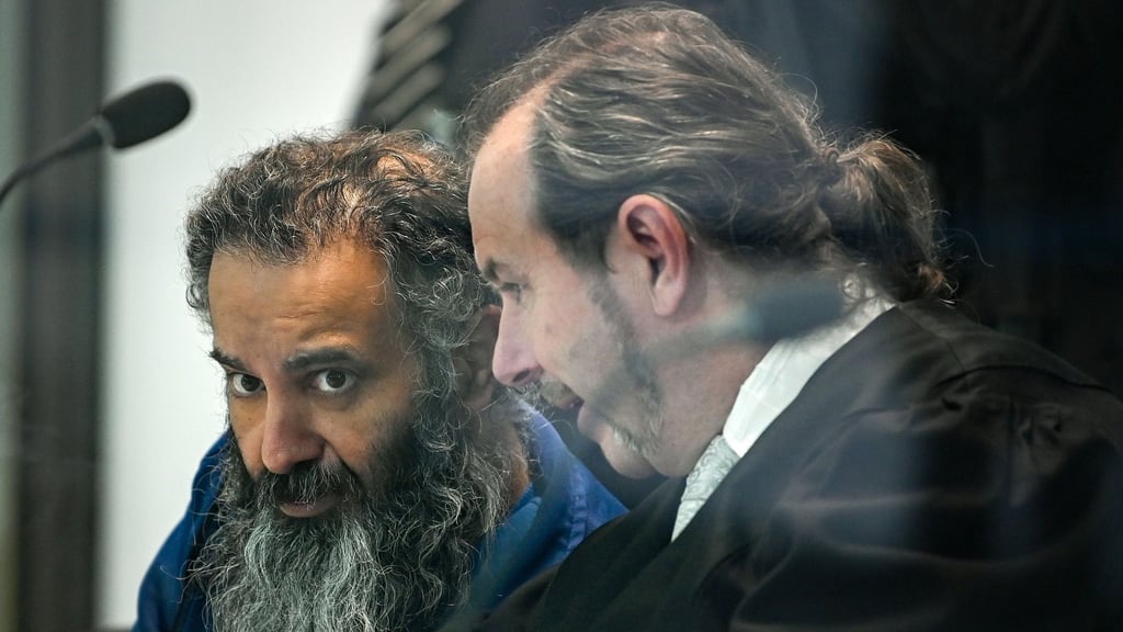 Der Angeklagte Taleb al-Abdulmohsen (l) sitzt neben Pflichtverteidiger Thomas Rutkowski in einem kugelsicheren Glaskasten im temporären Gerichtsgebäude des Landgerichtes Magdeburg.