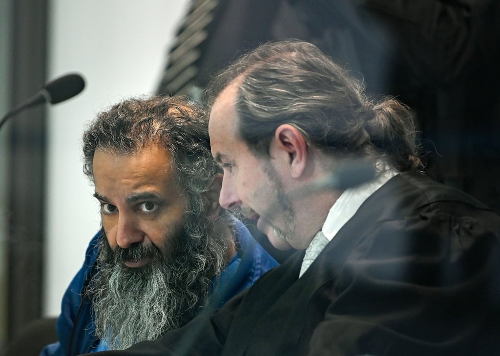 Der Angeklagte Taleb al-Abdulmohsen (l) sitzt neben Pflichtverteidiger Thomas Rutkowski in einem kugelsicheren Glaskasten im temporären Gerichtsgebäude des Landgerichtes Magdeburg.