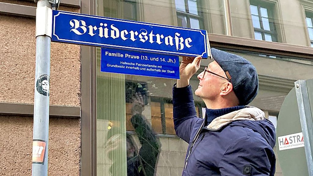 Dirk Herold vom Arbeitskreis Innenstadt bringt eine der Infotafeln an.