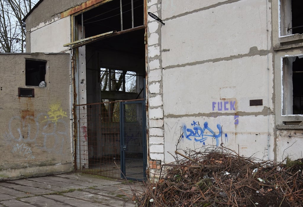 Der Eingang zu dieser alten Halle ist mit einem Zaun gesichert worden.