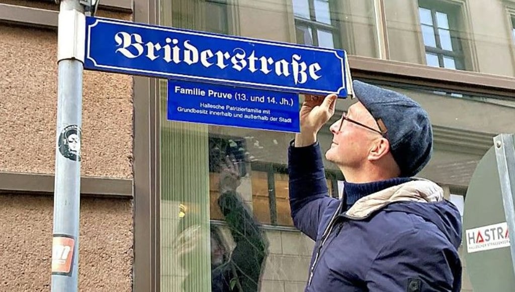 Dirk Herold vom Arbeitskreis Innenstadt bringt eine der Infotafeln an. 