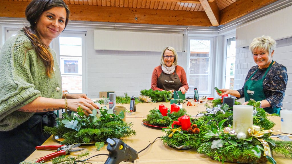 Tempo für den Weihnachtsbasar der Lebenshilfe Osterburg am Sonnabend, 22. November 2025 (von links): Alina Nickel, Silke Zehrau und Margit Schneider fertigen Gestecke.
