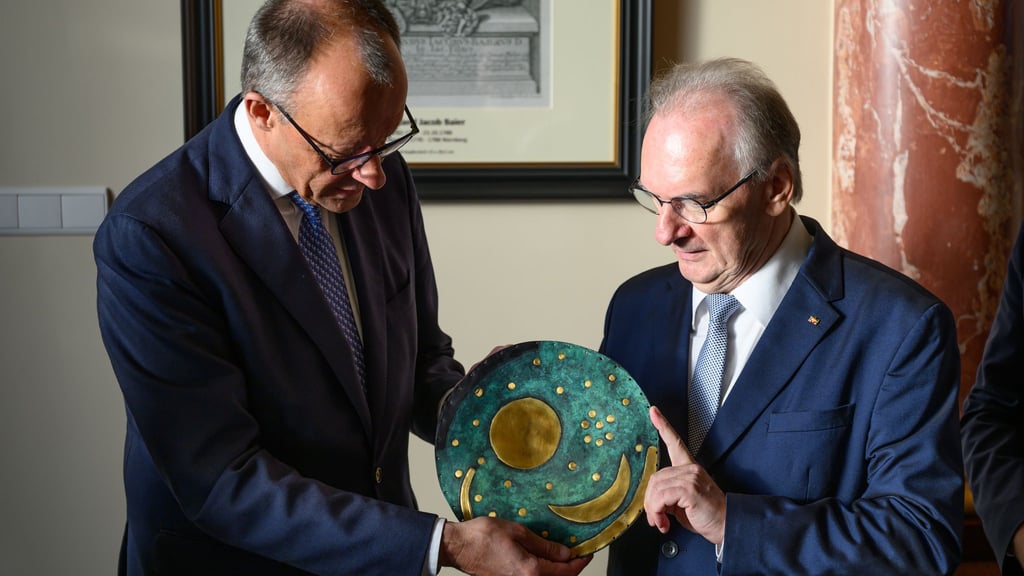 Merz nimmt eine Nachbildung der Himmelsscheibe von Nebra entgegen.