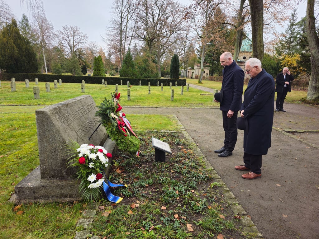 Andreas Dittmann und der Stadtratsvorsitzende Helmut Seidler legen zum Gedenken einen Kranz nieder.