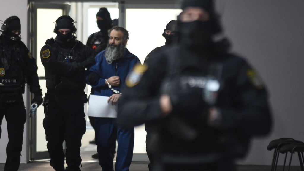 Der Angeklagte Taleb al-Abdulmohsen wird von Polizeibeamten in den Gerichtssaal geführt.