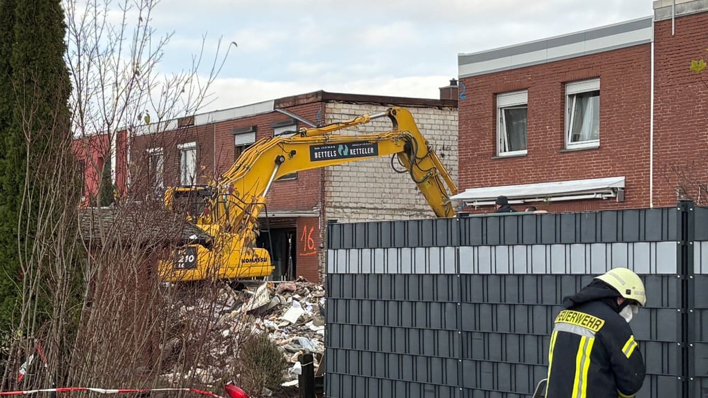 Ein Bagger räumt den Schutt eines eingestürzten Reihenhauses in Wolfenbüttel fort. In den Trümmern ist eine Leiche entdeckt worden.