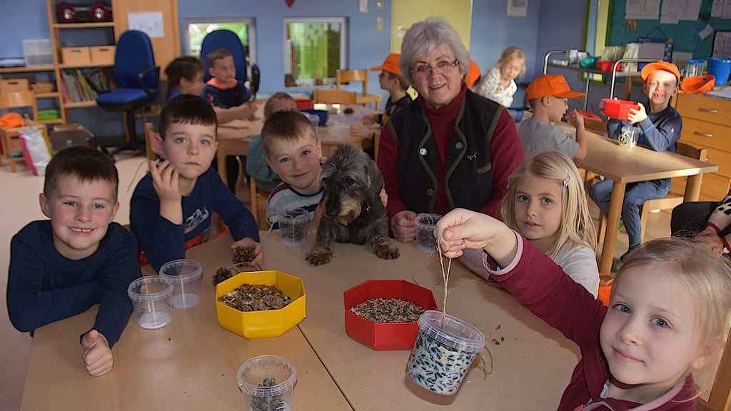 Große Hilfe für kleine Hände: Angela Kummert und Hündin „Waldfee“ helfen den Kindern der Calvörder Kita beim Basteln ihrer ersten Vogelfutterzapfen.