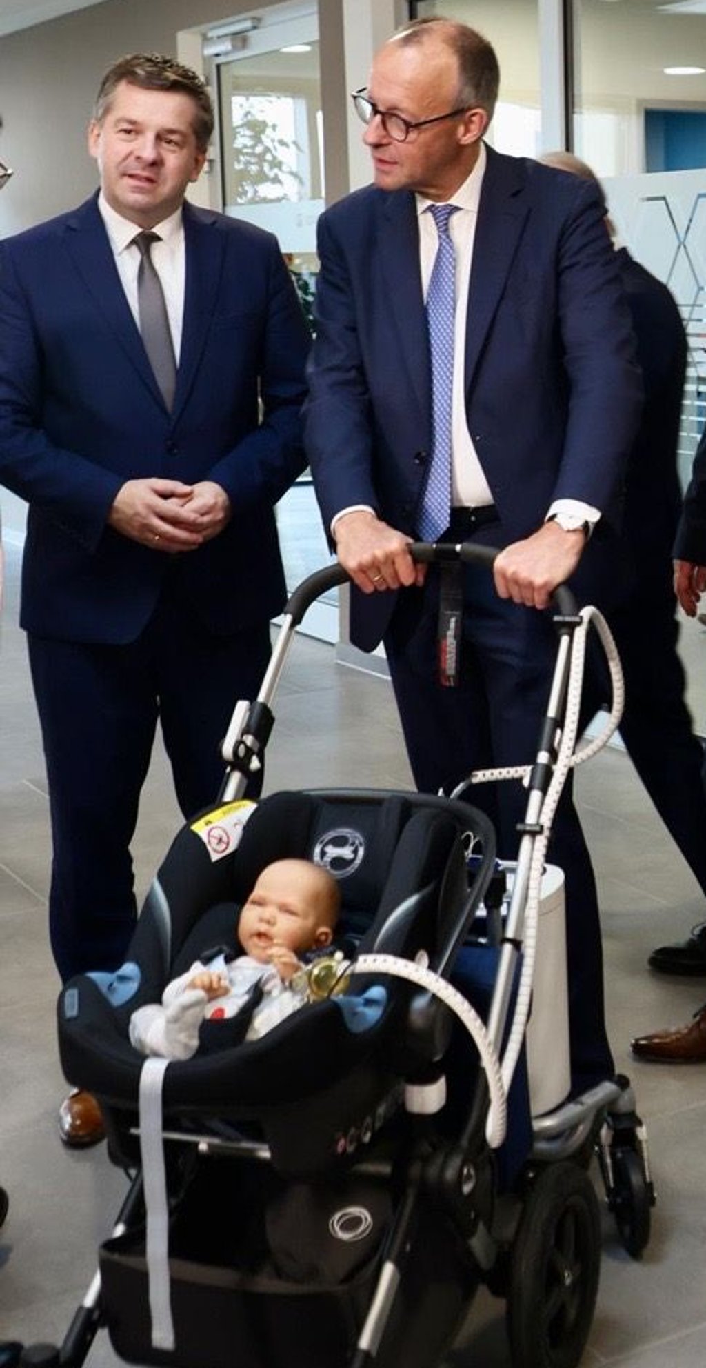 Kanzler Friedrich Merz (re.) und Landeswirtschaftsminister Sven Schulze (beide CDU) testeten bei Sonotec in Halle einen Kinderwagen mit Babypuppe und einen Ultraschallsensor für Kinder mit Herzkrankheit.