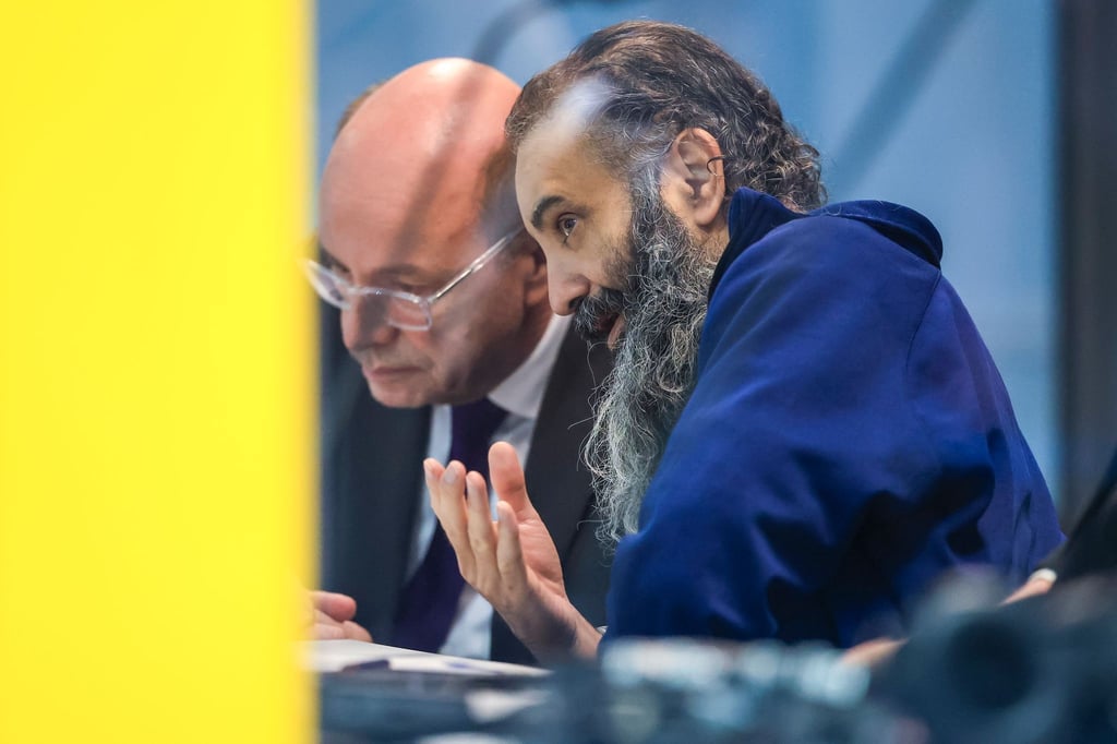 Der Angeklagte Taleb al-Abdulmohsen (r) sitzt neben einem Dolmetscher in einem kugelsicheren Glaskasten zur Prozessfortführung im temporären Gerichtsgebäude des Landgerichtes Magdeburg.