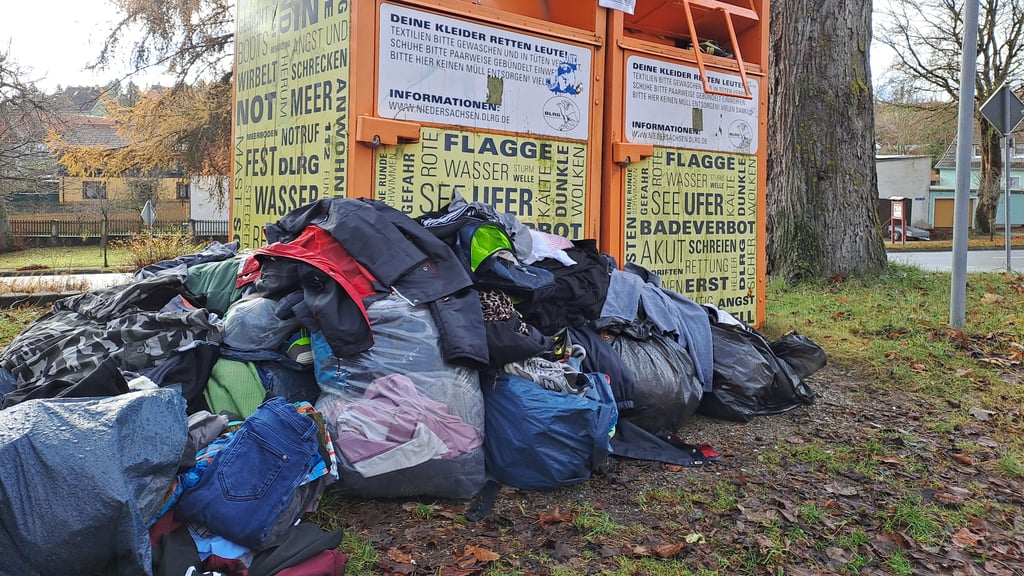 Ein überfüllter Altkleider-Container in Elbingerode. Zahlreiche Säcke werden davor abgelegt.