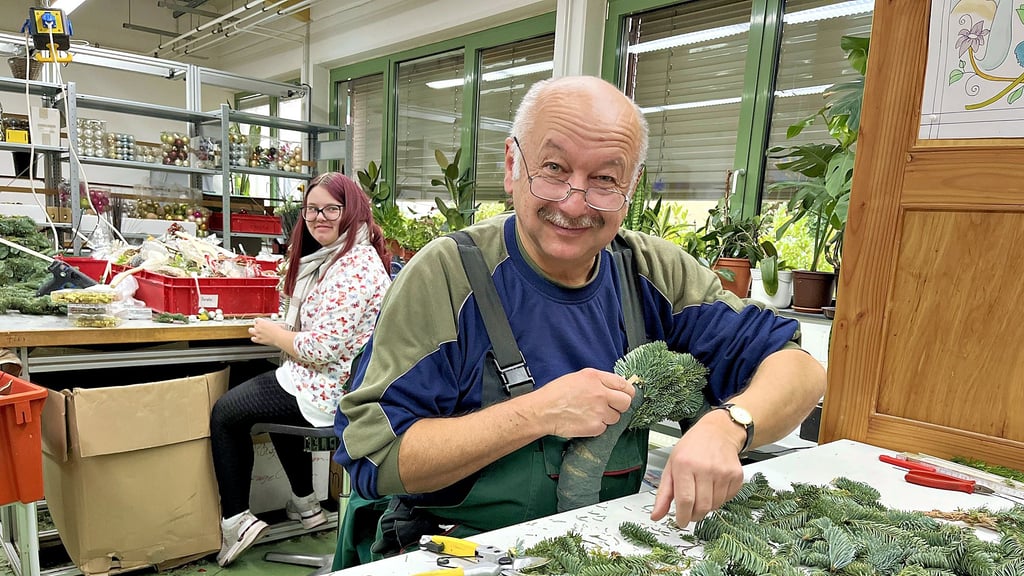In der Floristikwerkstatt der Lebenshilfe in Tangerhütte werden ganz frisch die Kränze aus Tannengrün gewickelt. Dirk Richter (vorn) macht das seit 26 Jahren und hat immer noch Spaß an allem, was die Weihnachtszeit verschönert. Kollegin Tabea Feindt im Hintergrund ist eine der Jüngeren in der Werkstatt.