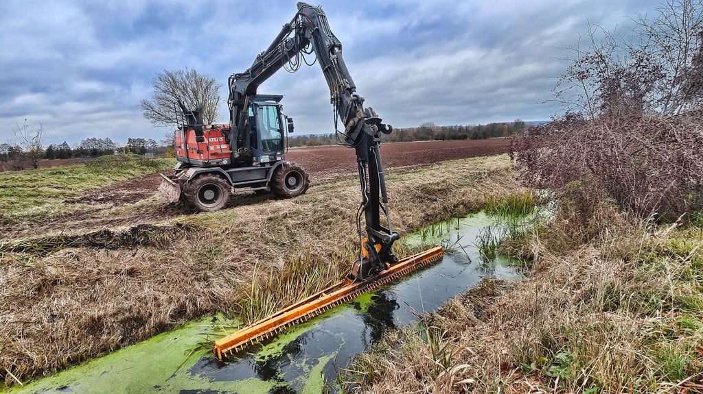 Silvio Liebau vom Unterhaltungsverband Helme entkrautet mit riesigen Mähkorb den Weidemühlengraben bei Kelbra.