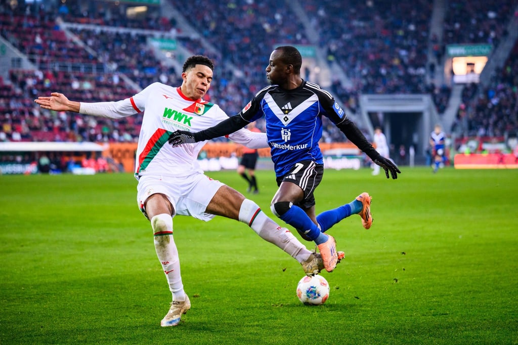 Augsburgs Noahkai Banks im Zweikampf mit Jean-Luc Dompé vom HSV.