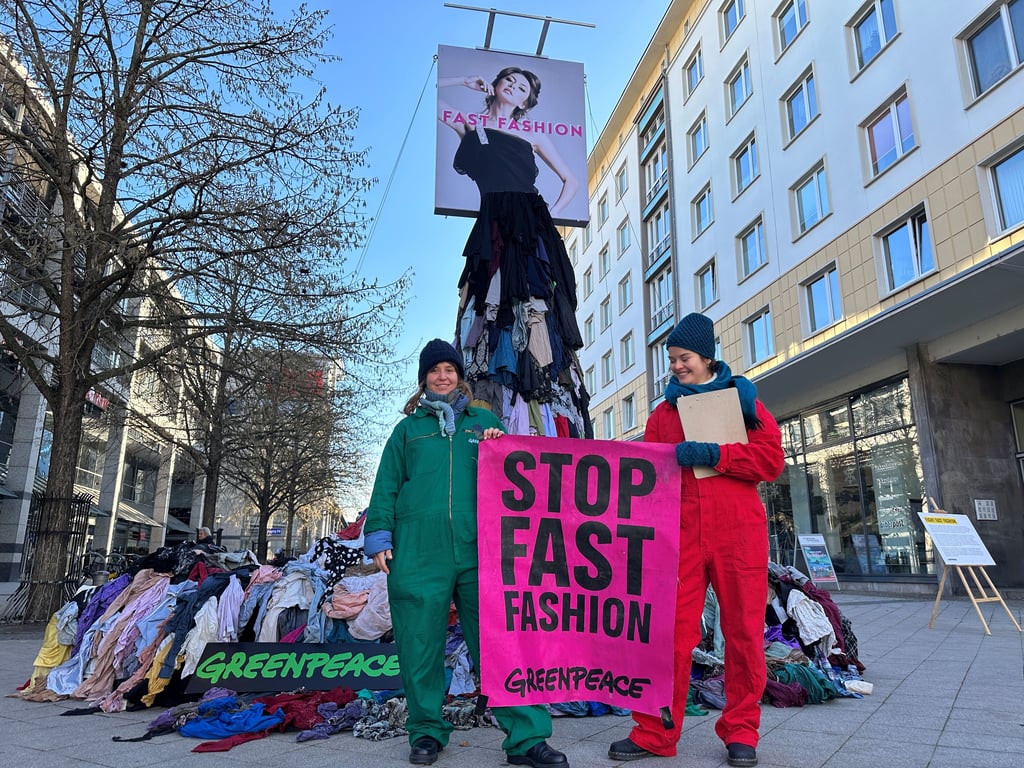 Jede Menge an Klamottenmüll haben Aktivisten von Greenpeace am Samstag (22. November 2025) in Magdeburg zu einer Skulptur aufgetürmt.