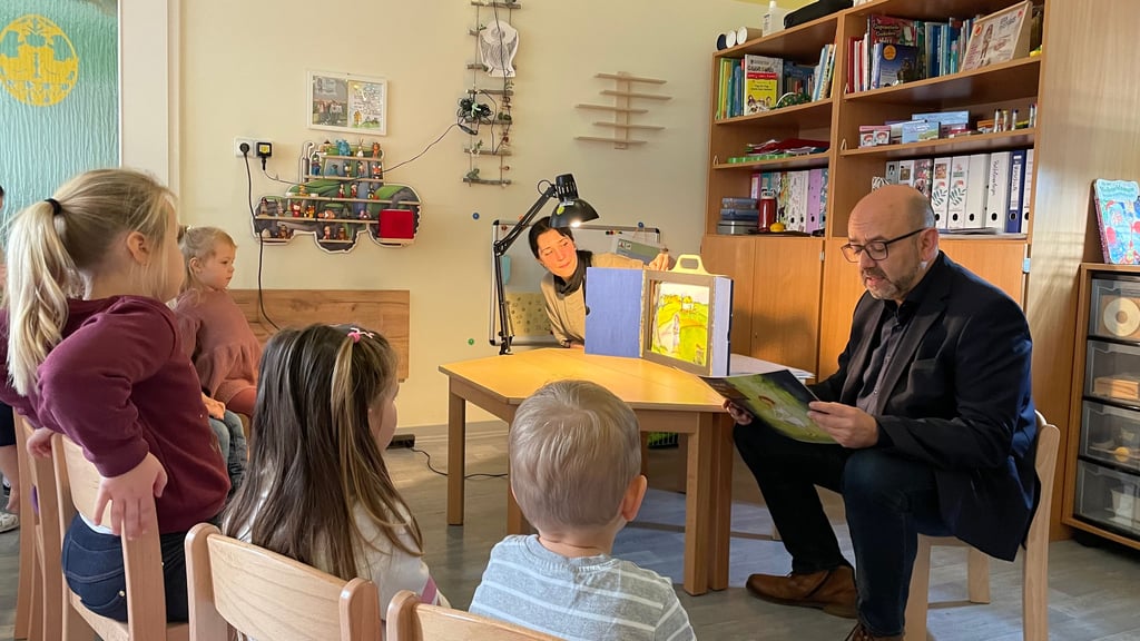 Hohenmölsens Bürgermeister Andy Haugk (parteilos, r.) und Bibliotheksmitarbeiterin Jana Herzig (hinten) lesen Kindern der Kita „Pfiffikus“ vor.