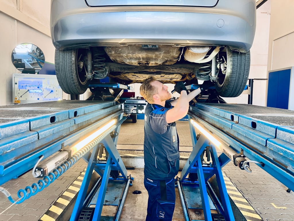 Tobias Otto untersucht beim TÜV Nord die Unterseite eines Pkw.