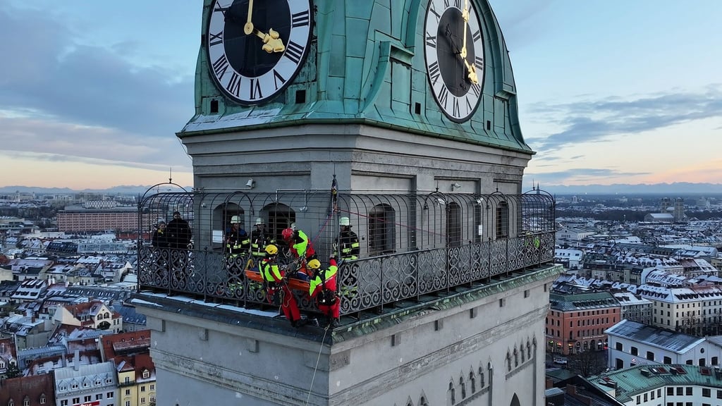 Kräfte der Berufsfeuerwehr München sind am Turm der Kirche St. Peter im Einsatz.
