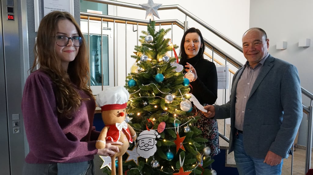 Im Rathaus steht ein Wunschbaum. Auszubildende Loona Hintz, Pressesprecherin Julia Schneider und stellvertretender Bürgermeister Jens Sonnabend hoffen, dass alle Wünsche erfüllt werden.