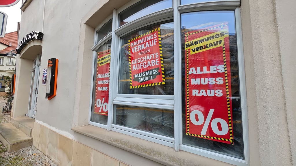 Knallrote Schilder kündigen das Ende des Check-in-Stores in Sangerhausen an.