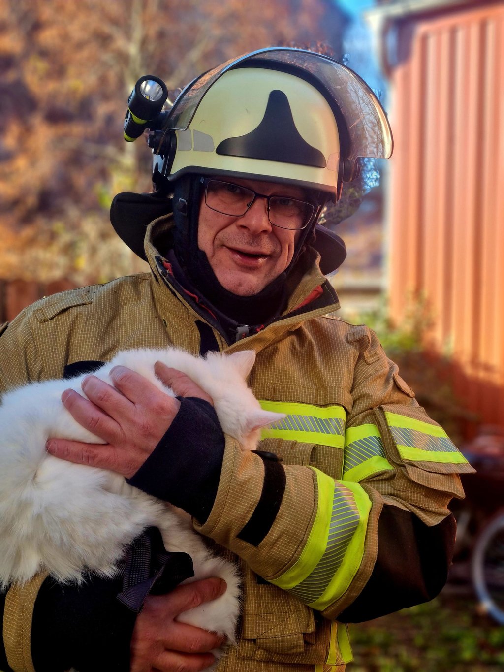 Glückliches Ende von einem tierischen Einsatz in Burg: Michael Richter von der freiwilligen Feuerwehr hält die Katze, die in einen Baum geklettert und nicht wieder selbst heruntergekommen war, in den Armen.