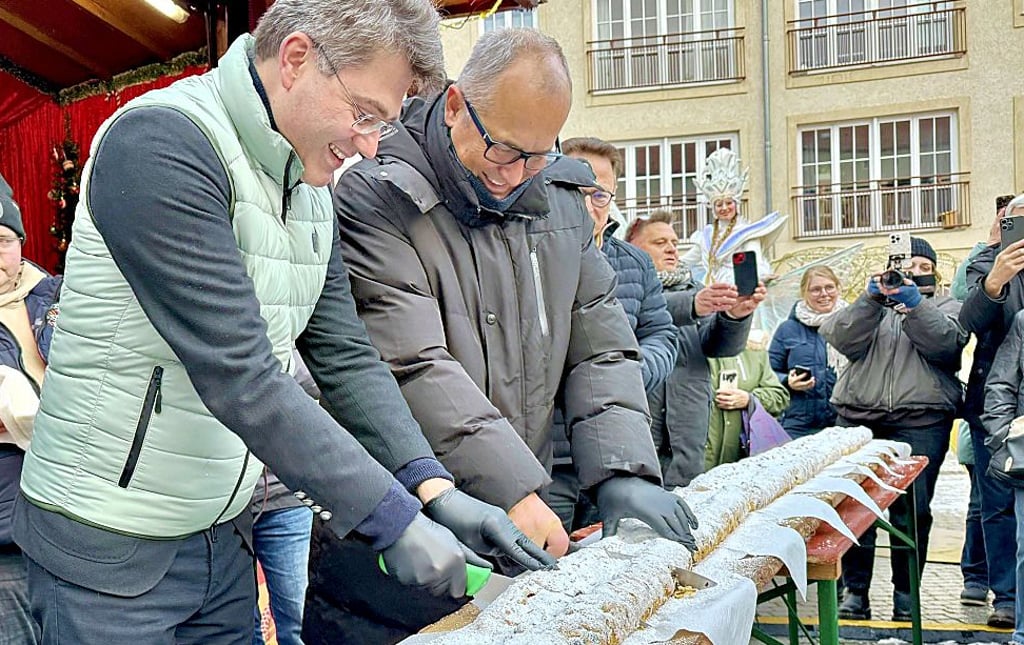 Robert Reck (links) und Dirk Merkel schneiden die Stolle an.