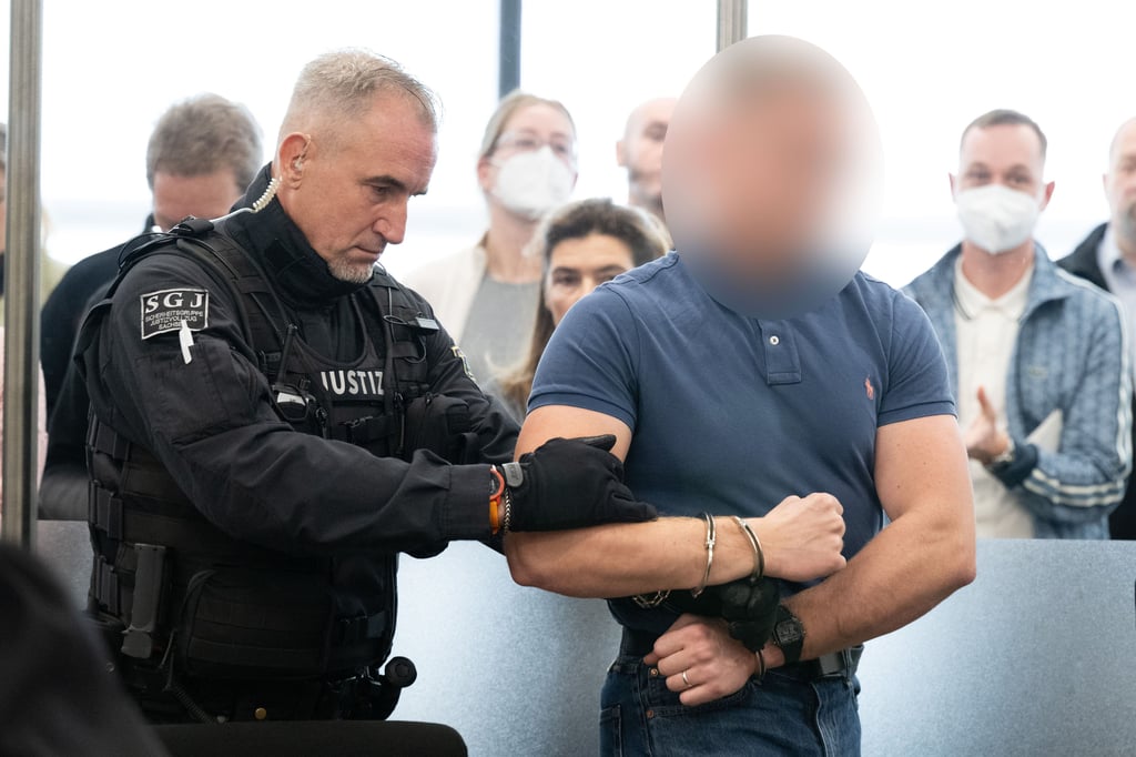 Linksextremismus-Prozess am OLG Dresden: Einer der Angeklagten wird von einem Justizbeamten in den Saal geführt.