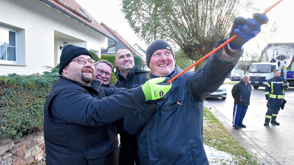 „Schreib mal, die Faschingskanuten ziehen an einem Strang“,  diktiert Andy Trübe (l.)  dem Volksstimme-Fotografen in den Block.  Die  Karnevalsfrohnaturen  Michael Schönwiese, Guido Fritsche und Michael Wolfram halfen beim Fällen  des aktuellen Barbyer Markt-Weihnachtsbaumes im Wohngebiet Spittelbreite. 