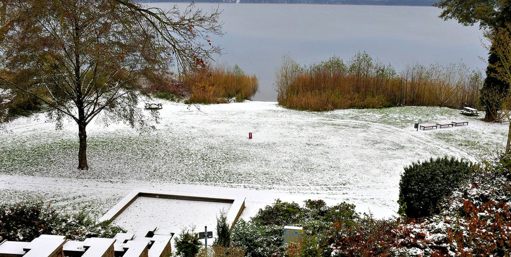 Blick von der Kaskade auf den winterlichen Arendsee mit dem eingeschneiten Wasserfall. 