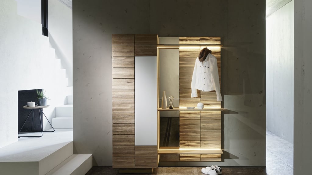 Ein Schrank mit Spiegel und Beleuchtung im Flur sorgt für Stauraum und ist praktisch, um kurz einen Blick aufs Outfit zu werfen.