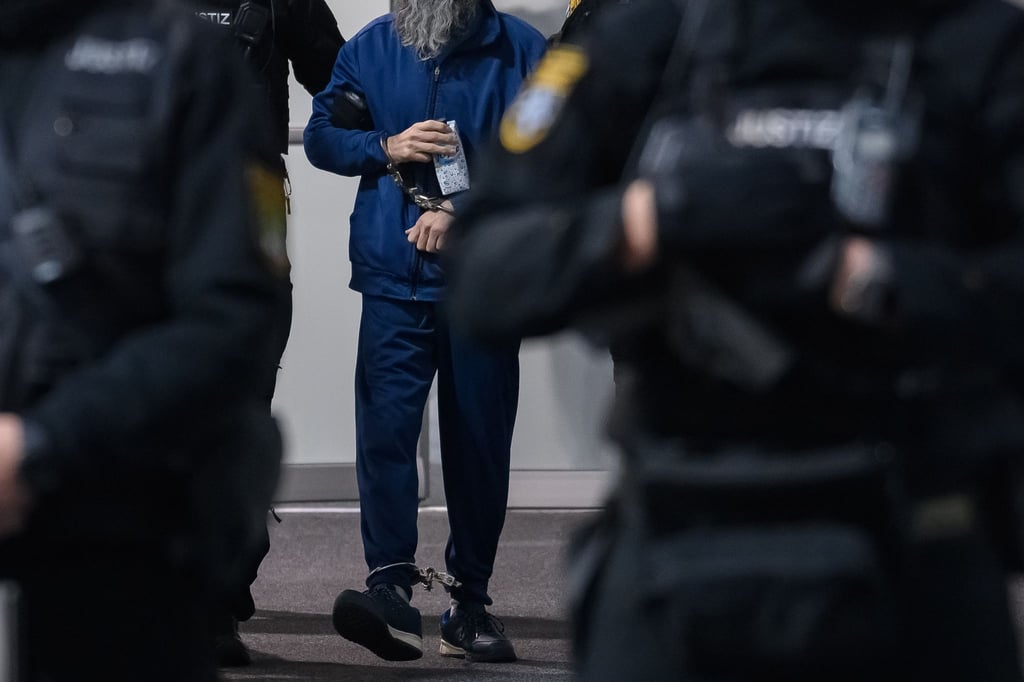 Justizbeamte führen den Angeklagten Taleb al-Abdulmohsen (M) in den Gerichtssaal des temporären Gerichtsgebäude des Landgerichtes Magdeburg.