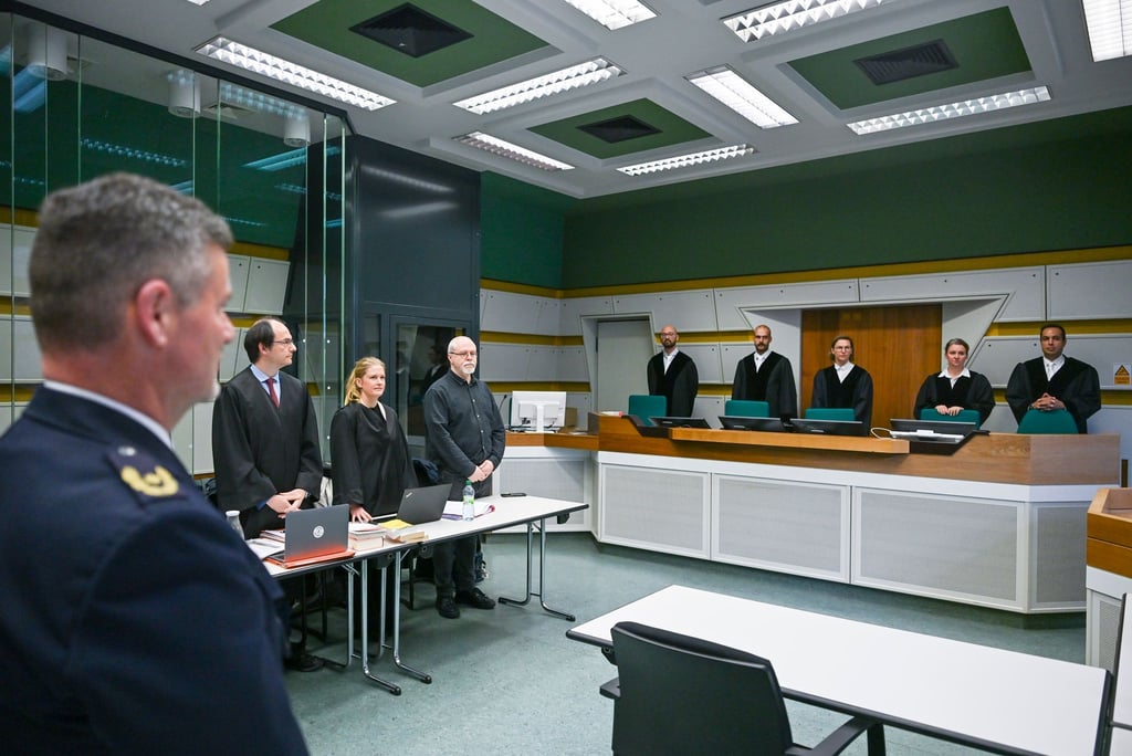 In einem Gerichtssaal stehen der Zeuge Stephan Katte (l), Direktor bei der Polizei Berlin, und der Kläger Wieland Hoban (4.v.l.).
