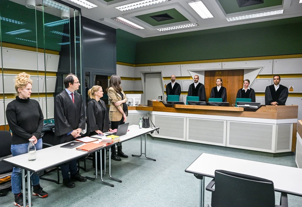Im Gerichtssaal stehen Anwälte (l) mit der Klägerin und die Richter der 1. Kammer des Verwaltungsgerichts.