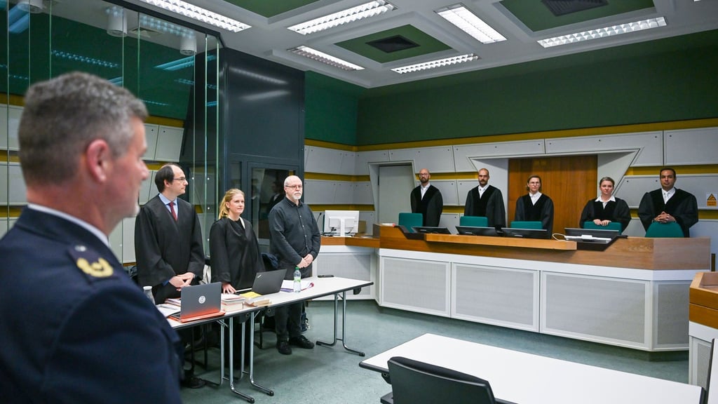 In einem Gerichtssaal stehen der Zeuge Stephan Katte (l), Direktor bei der Polizei Berlin, und der Kläger Wieland Hoban (4.v.l.).