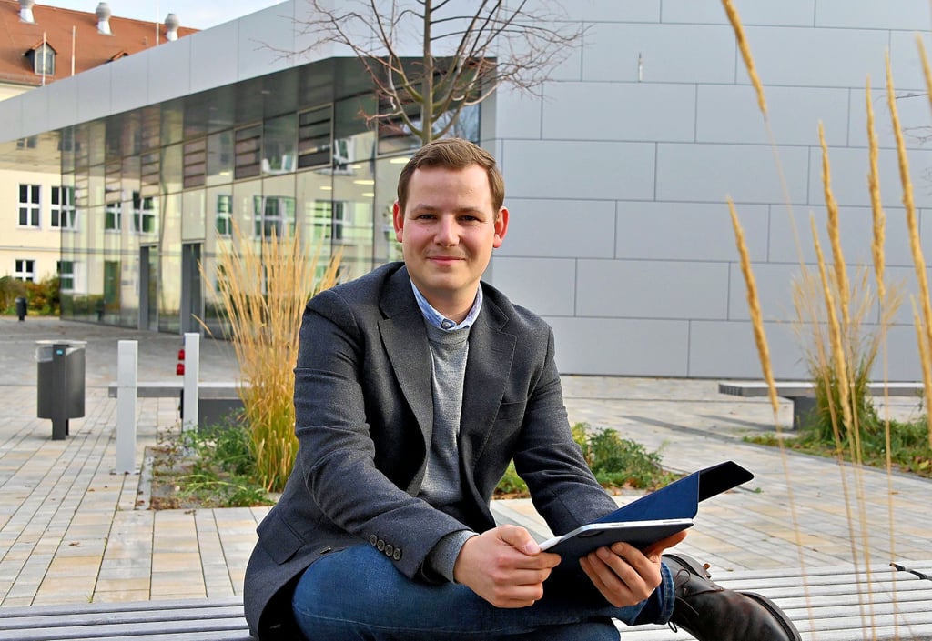 Niclas Groth hat vor dem neuen Hörsaal der Medizinischen Fakultät in Magdeburg Platz genommen.