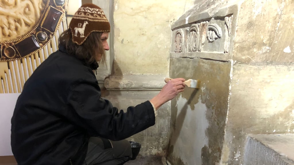 Für das Anlegen einer Musterfläche für die Präsentation der romanischen Stuckfragmente in der Stiftskirche in Quedlinburg trägt Restauratorin Corinna Scherf  auf dem Sockel eine Grundierung auf.