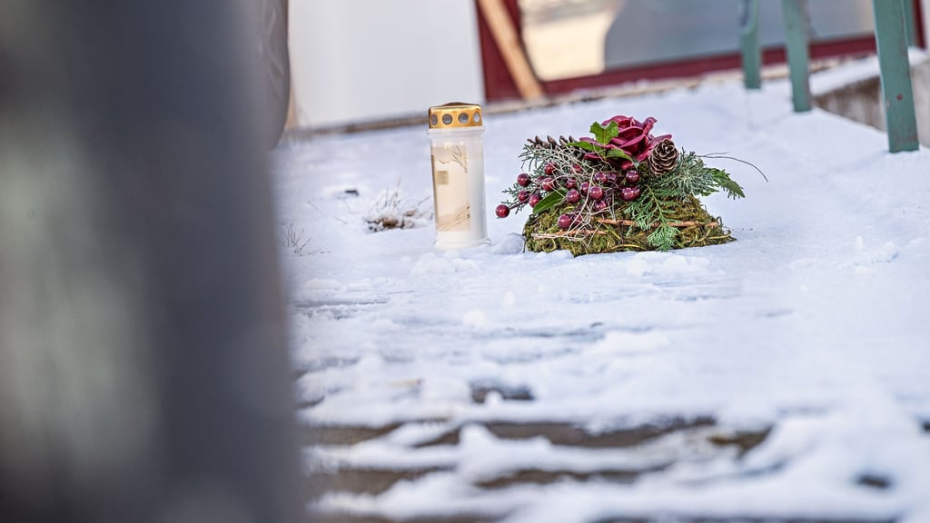 Vor dem Firmengebäude, in dem die Leichen der beiden Söhne gefunden wurden, liegen eine Kerze und ein Kranz.