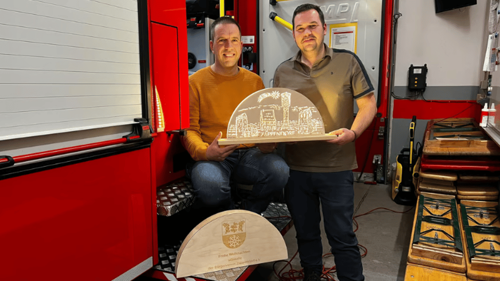 Maik Rose (l.) und Alexander Rühl halten stolz die kleine Version des Zappendorfer Schwibbogens in den Händen.