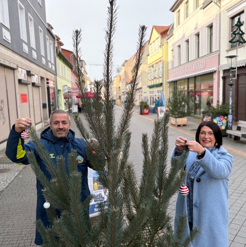 Cornelia Gentz vom gleichnamigen Schuh- und Lederwarengeschäft und Andreas Borghardt vom Reisebüro "Vetter Touristik" beim Gestalten eines Weihnachtsbaumes, der Teil des Pop-up-Wintrerwaldes in Burg ist. Dieser ist eine Aktion vom Campus-Projekt.