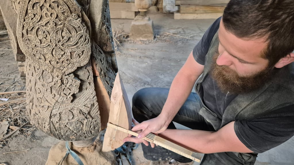 Restaurator Jonas Kinast setzt ein kaputtes Stück am Boden einer Holzsäule in der Juma-Moschee in Usbekistan aus. 